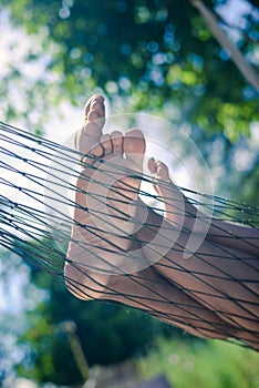 Closeup of happy family lying on hammock on sunny countryside background.