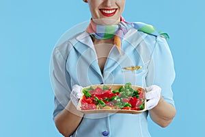 Closeup on happy female stewardess on blue