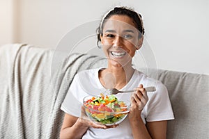 Closeup of happy lady holding fresh salad