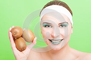 Closeup of happy woman holding kiwi