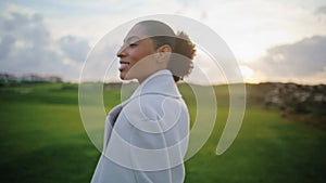 Closeup happy woman spinning on cloudy sunset. Serene black hair girl close eyes