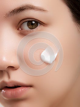 Closeup happy young woman applying cream to her face Skincare and cosmetics concept. Cosmetics. Woman face