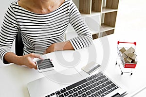 Closeup of happy young woman holding credit card inputting card