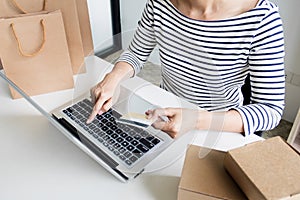 Closeup of happy young woman holding credit card inputting card