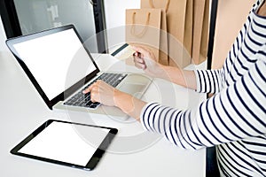 Closeup of happy young woman holding credit card inputting card