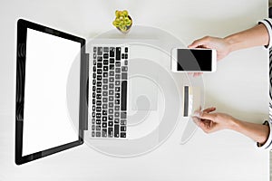 Closeup of happy young woman holding credit card inputting card