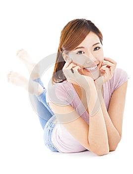 Closeup of happy young woman lying prone on the floor