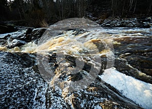 Closeup of the harsh flow of a rocky river with a silky water effect