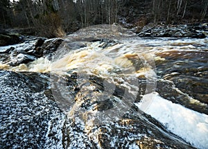 Closeup of the harsh flow of a rocky river with a silky water effect