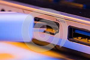 Closeup of HDMI cable plug inserted into port on the side of a l