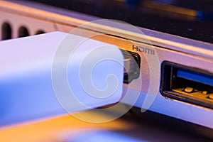 Closeup of HDMI cable plug inserted into port on the side of a l