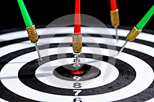 Closeup head of dart arrows hitting target center Dart board on black background