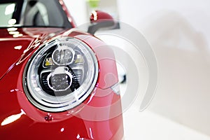 Closeup headlight of red sport car background