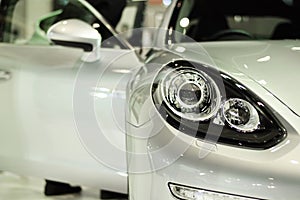 Closeup headlight of sport silver car background