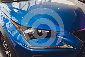 Closeup headlights of car blue body close-up. gray body