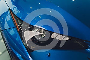Closeup headlights of car blue body close-up. gray body