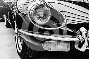 Closeup of the headlights and front bumper on vintage automobile