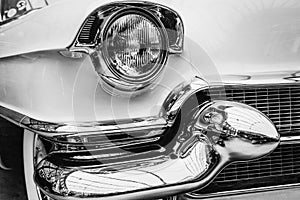 Closeup of the headlights and front bumper on vintage automobile photo