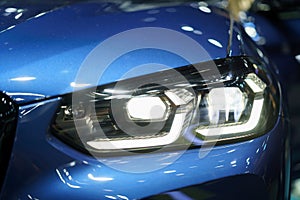 Closeup headlights of modern car during turn on light in night photo