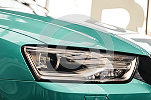 Closeup headlights of a modern Mint color car