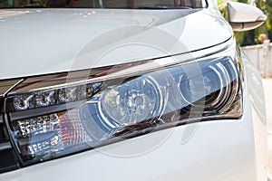 Closeup headlights of modern white car with LED daylight