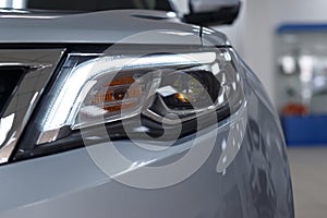 Closeup headlights of a modern white color car. Detail on the front light of a car