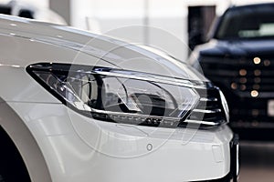 Closeup headlights of a modern white color car. Detail on the front light of a car. Modern and expensive car concept