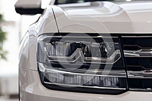 Closeup headlights of a modern white color car. Detail on the front light of a car. Modern and expensive car concept