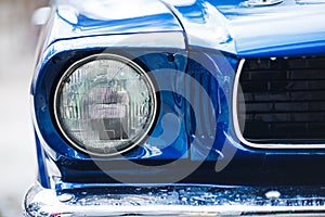 Closeup headlights of retro muscle car. Car exterior detail