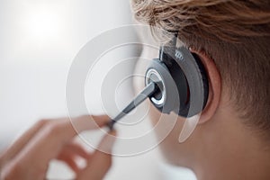 Closeup, headset in call center with woman, consultant or telemarketing in office. Contact us, crm or consulting in