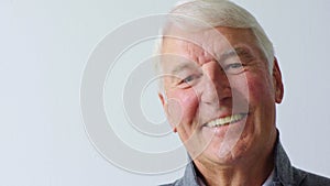 Closeup headshot and face of one senior, carefree and cheerful man giggling at a funny joke. Portrait of a laughing