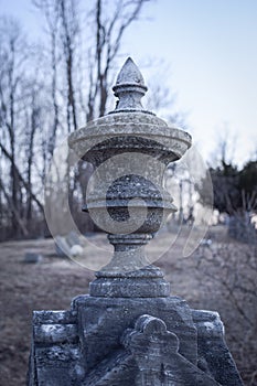 Closeup of headstone ornament at an old delapidated looking graveyard on a gray gloomy day in Upstate New York