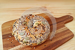 Closeup a healthy pumpkin seed and sunflower seed with sesame bagel on wooden breadboard