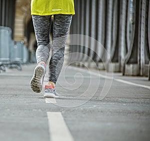 Closeup on healthy woman jogging on Pont de Bir-Hakeim bridge