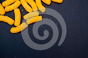 Closeup of the heap of corn cheese on dark background.