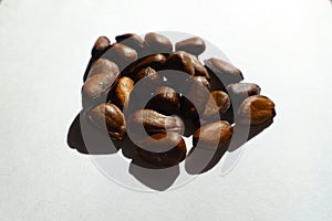 Closeup of heap of dark brown bean-like glossy seeds of cherimoya