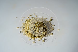 Closeup of heap of greenish yellow shelled hemp seeds