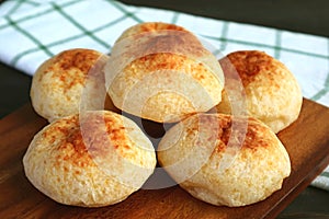 Heap of Homemade Brazilian Cheese Breads Called Pao de Queijo on Wooden Breadboard photo