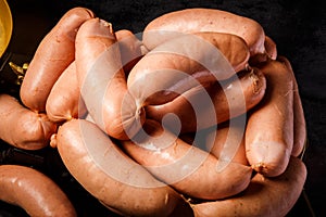 closeup heap of raw short thick wieners rolled in spiral on scales