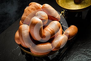 Closeup heap of short thick wieners rolled in spiral on scales