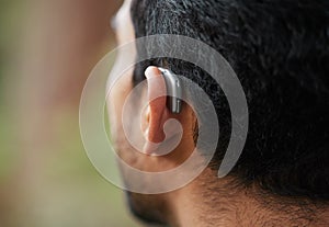 Closeup of hearing aid, ear and man with disability from the back for medical support, listening and healthcare tech