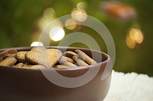 Closeup with hearts of gingerbread cookies on background of Christmas tree lights