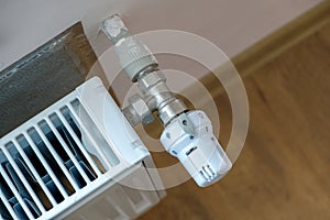 Closeup of heating radiator valve for comfortable temperature regulation on metal radiator on inrerior wall