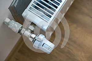 Closeup of heating radiator valve for comfortable temperature regulation on metal radiator on inrerior wall