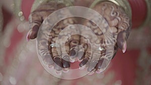 Closeup of henna applied hands of Indian Bride getting ready for her traditional Indian Wedding