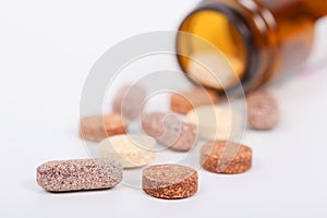 Closeup of herbal vitamin and supplement pills with herbs.