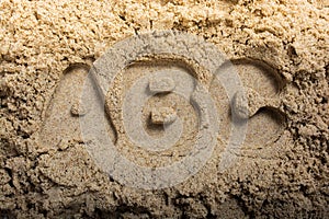 Closeup high angle shot of the letters ABC engraved on sand captured on a sunny day