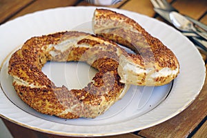 Closeup high angle shot of a traditional Istanbul bagel simit for breakfast on a white plate