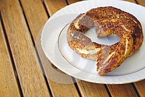 Closeup high angle shot of a traditional Istanbul bagel simit for breakfast on a white plate