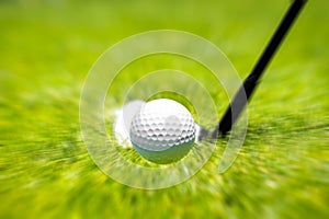 Closeup of hitting golf ball with golf iron club golf course wih motion blur effect